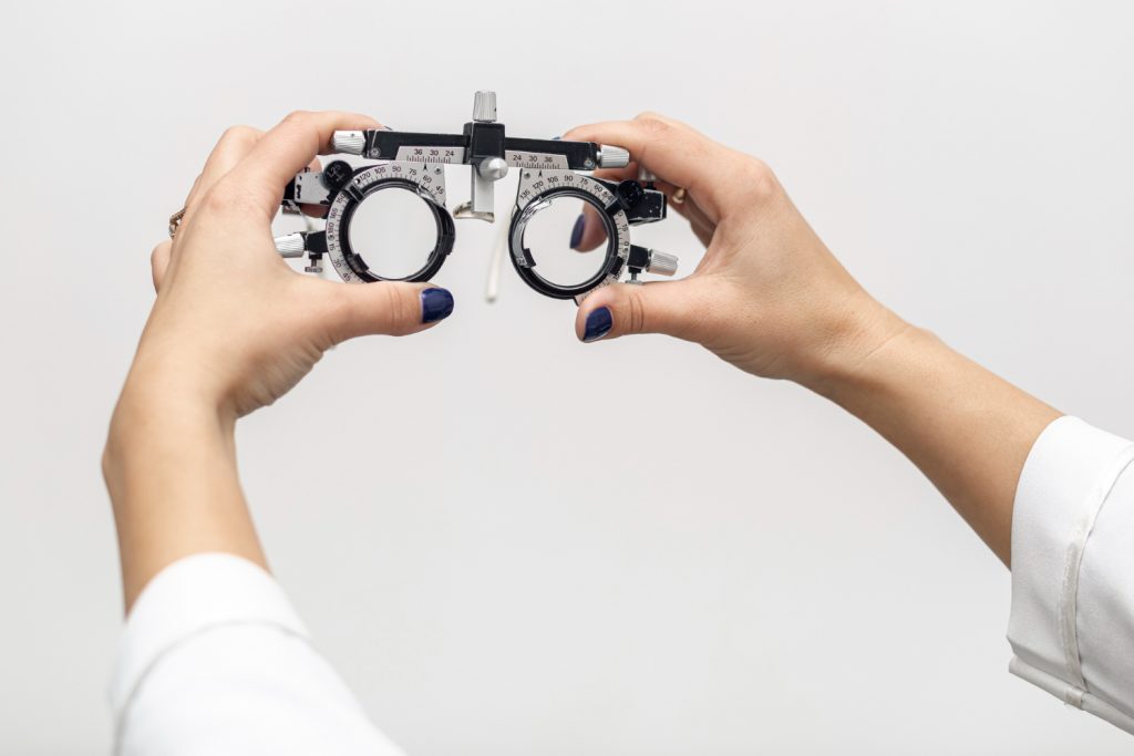 vista frontal mujer sosteniendo equipos opticos Tu examen de la vista, al detalle